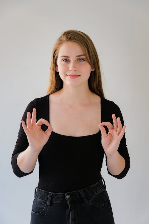 Free Portrait of Smiling Woman Showing Sign Language Stock Photo
