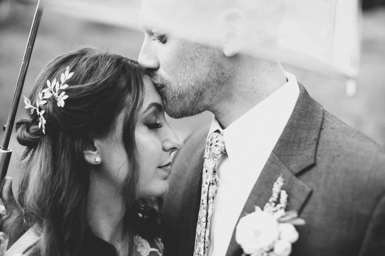 Groom kissing bride's forehead