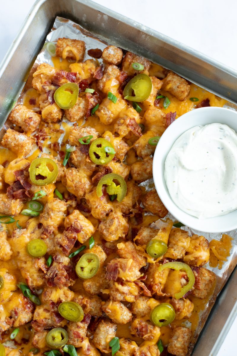 A tray of loaded tater tots with cheese, bacon and jalapenos.