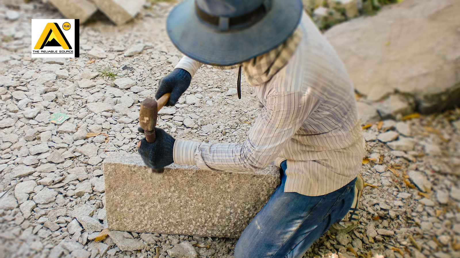 A worker chisels granite into a stepping stone