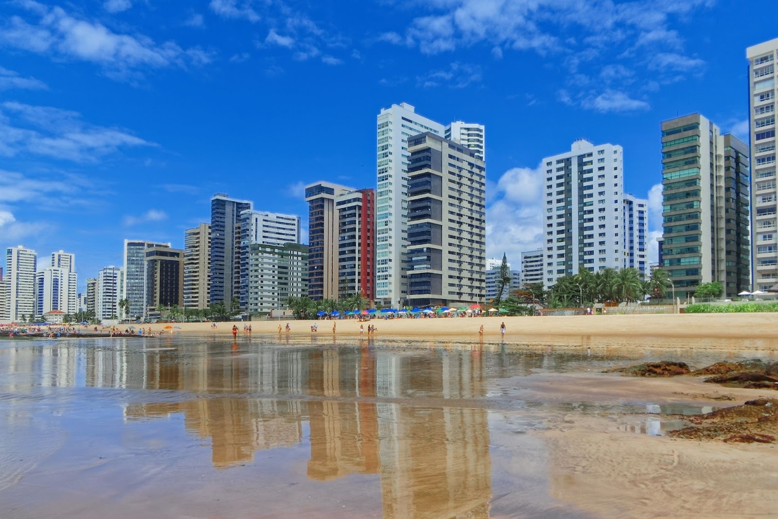 Praia de Piedade em Jaboatão dos Guararapes. Foto tirada com vista para a orla repleta de prédios de diferentes tamanhos, faixa de areia e águas cristalinas do mar