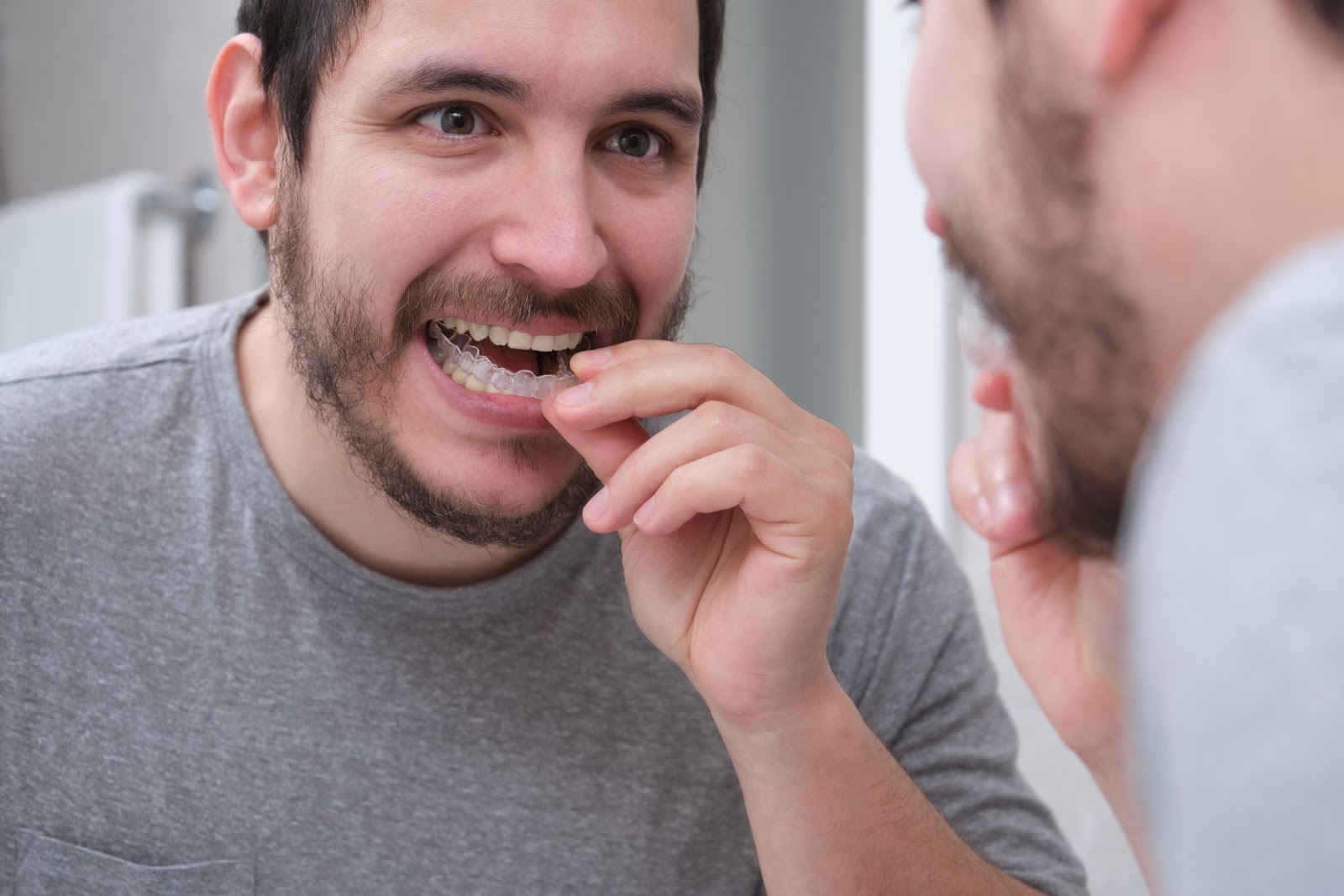 Man looking at mirror about to wear his clear aligners