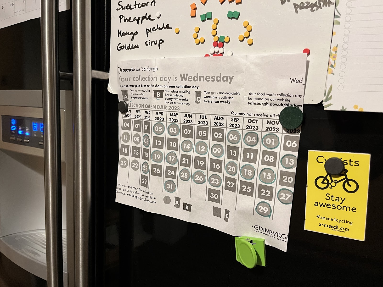 photo of a recycling bin calendar attached to the door of a fridge