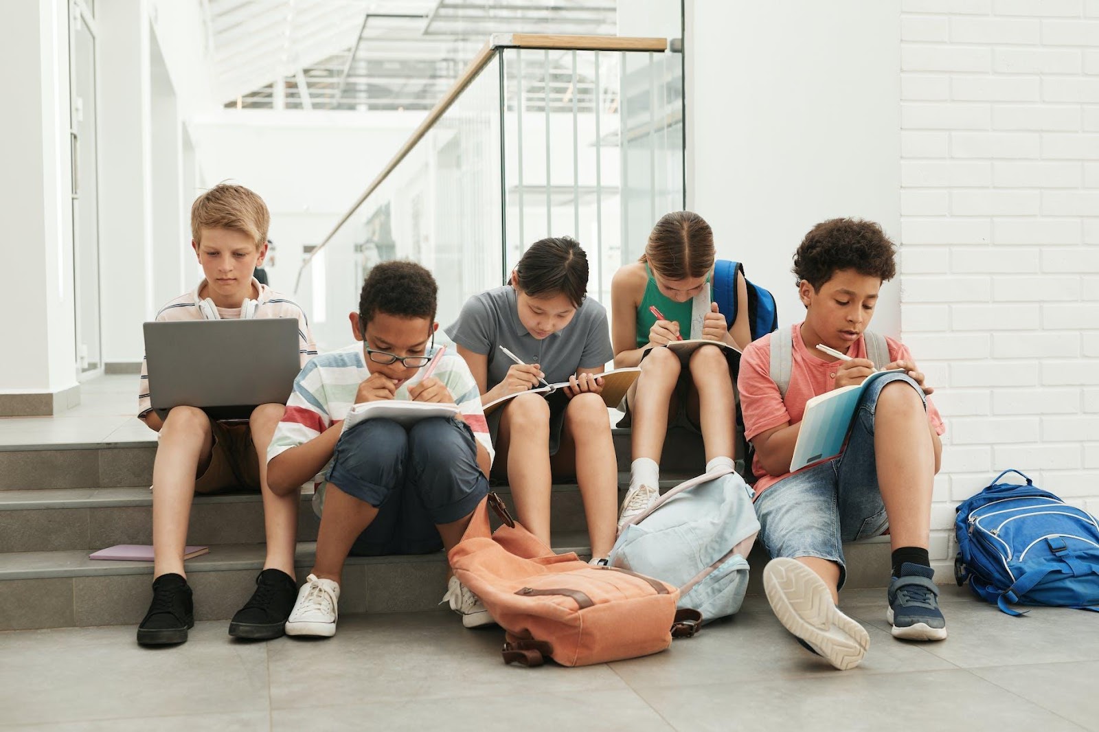 3 Boys and 2 Girls Sitting on Floor Using Macbook