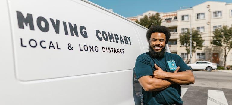  A smiling mover next to the moving truck.