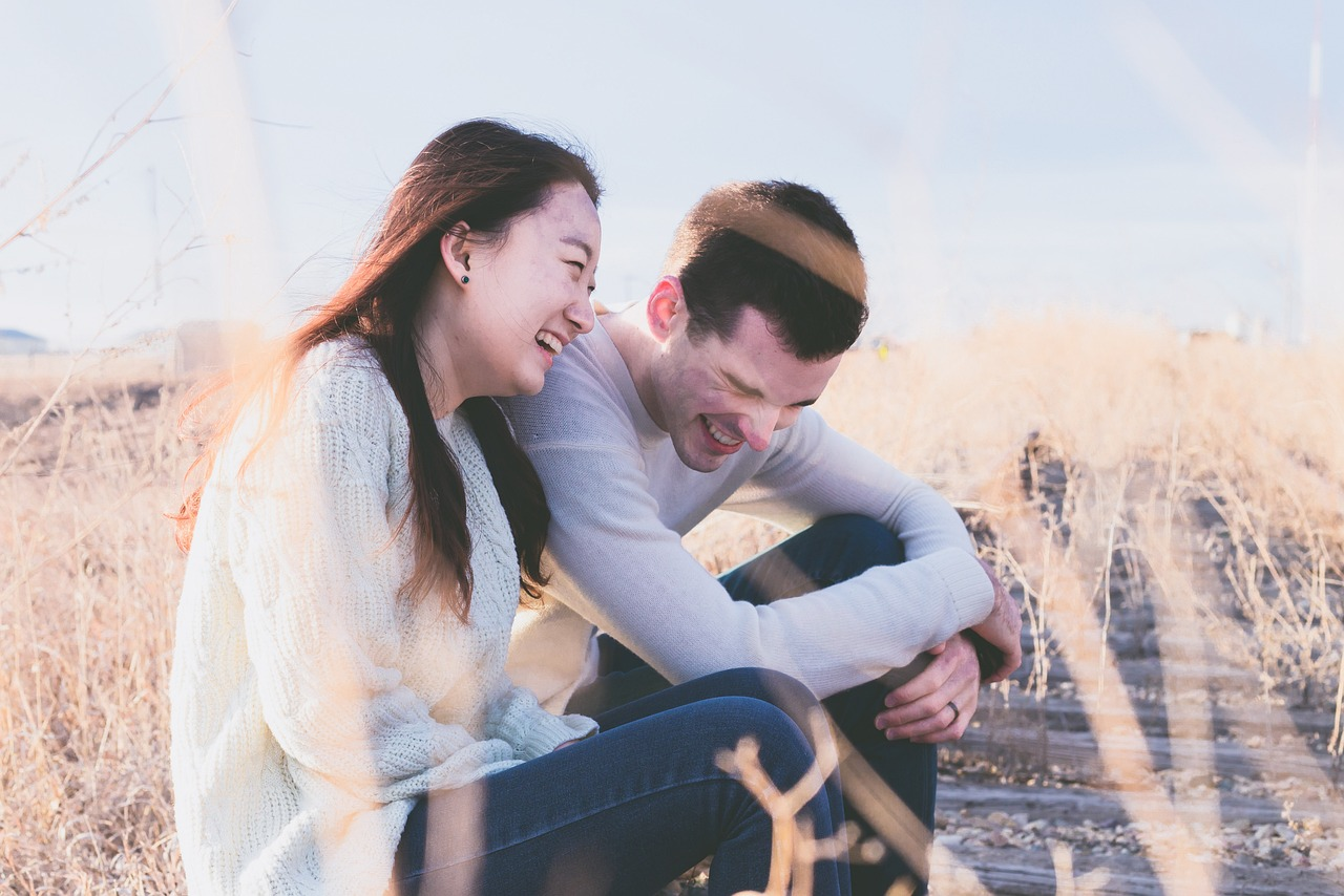 Homme et femme riant ensemble au soleil, améliorant leur bien-être et leur longévité
