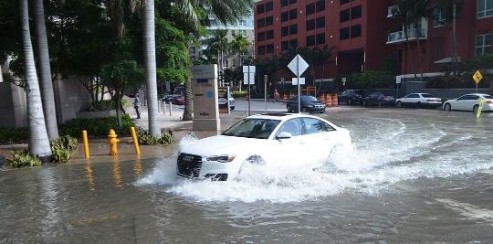 A car driving through a flooded street

Description automatically generated