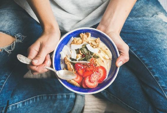 A person holding a plate of food  Description automatically generated