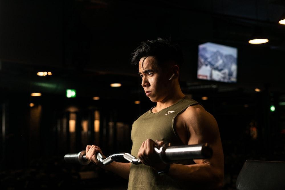 a man holding a bar in a gym