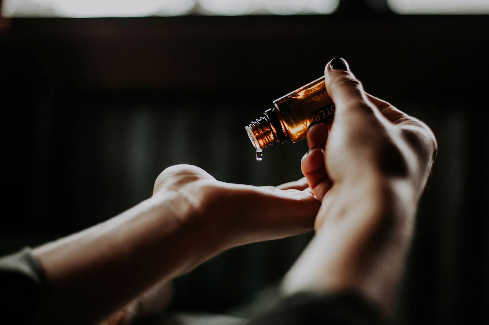 Women dropping essential oil on her hand for aromatherapy. 