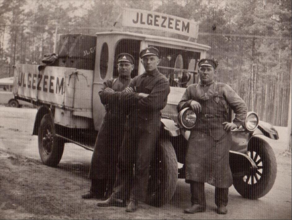 A group of men standing next to a truck

Description automatically generated