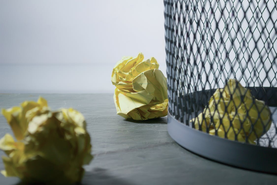 Free Focus Photo of Yellow Paper Near Trash Can Stock Photo