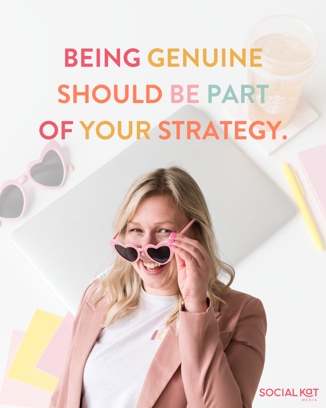 Being genuine should be part of your strategy. A woman in a pink blazer looks out playfully from behind heart shaped glasses.