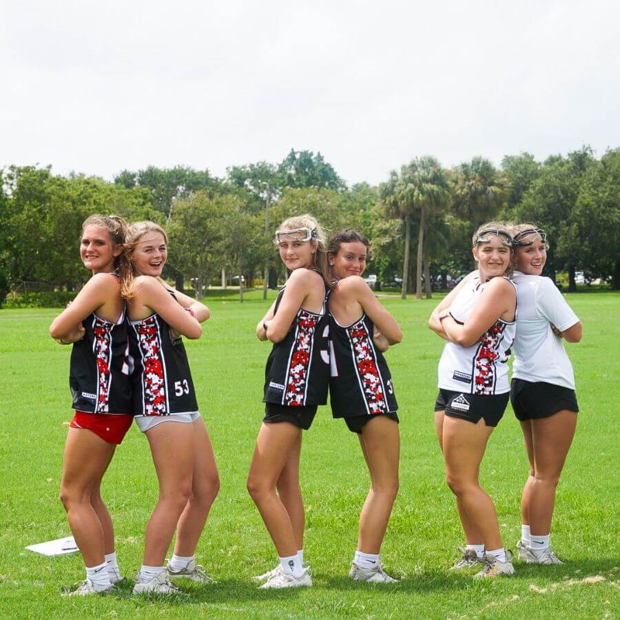 Girls at overnight sports camp pose for a picture while on the lacrosse field