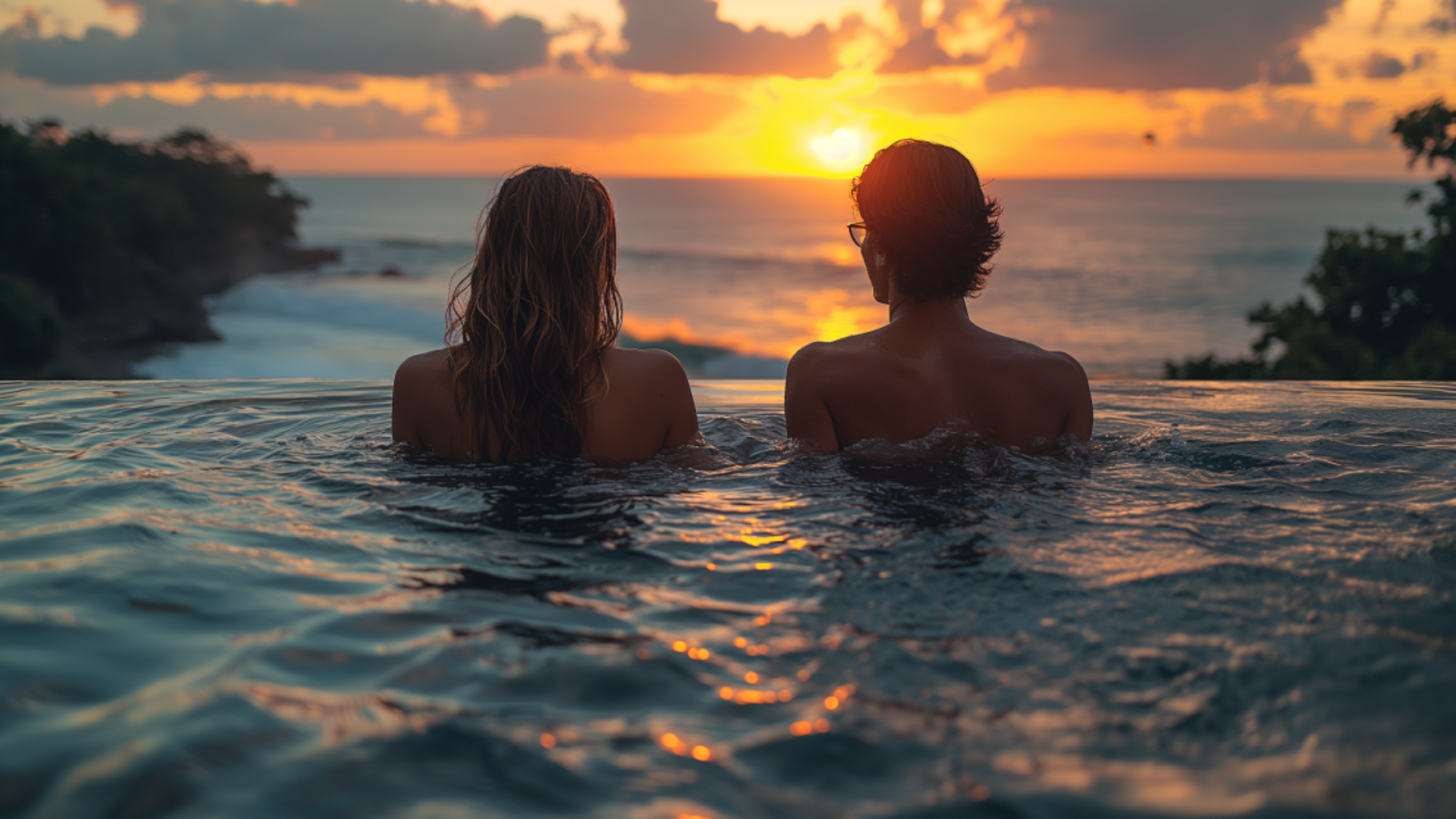 A couple relaxing in a private infinity pool at sunset overlooking the Adriatic Sea.