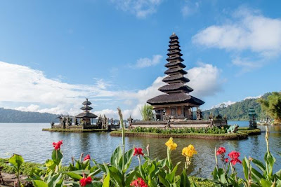 Two temples on the water surrounded by flowers in Bali