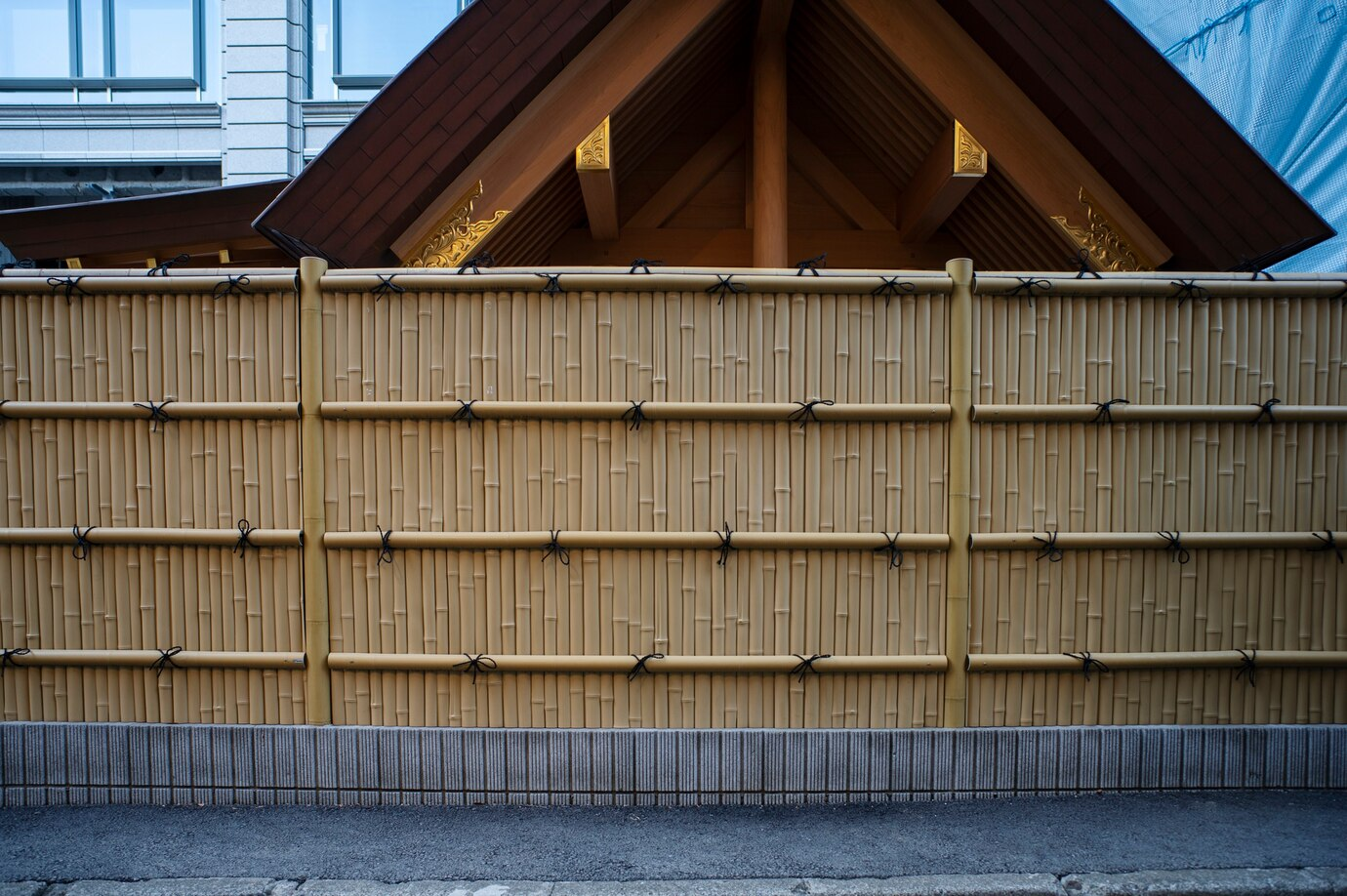 A bamboo outdoor privacy screen adorning a hybrid traditional-modern house