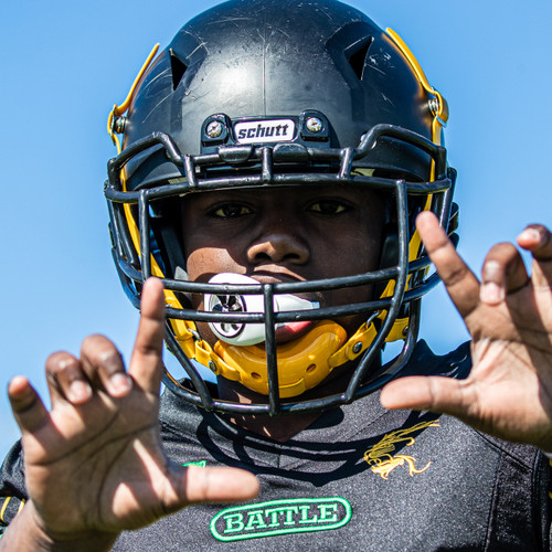 Football player wearing a white Battle Spinner Oxygen Football Mouthguard