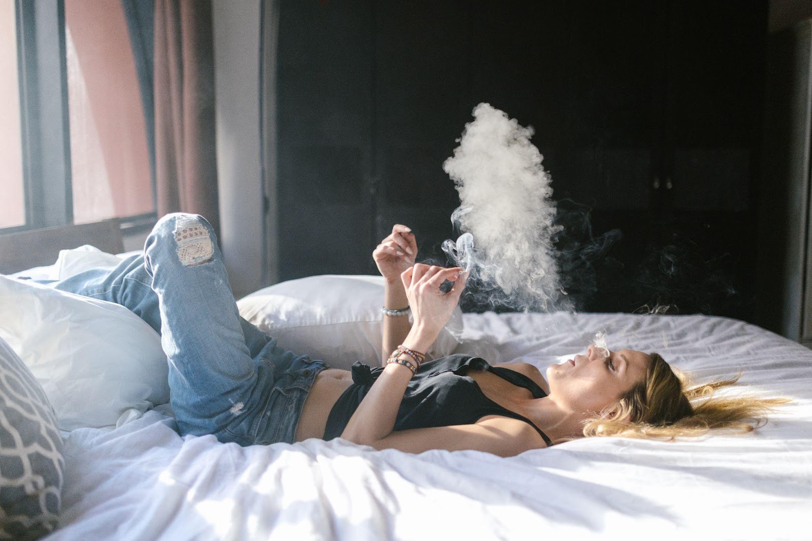 a woman smoking weed in bed