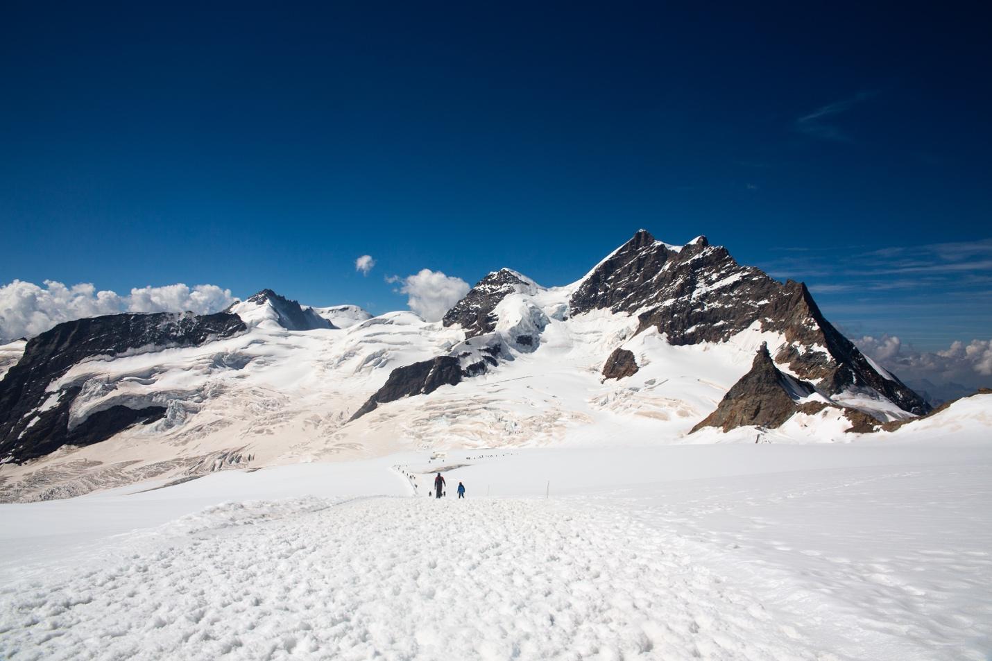 A group of people hiking on a snowy mountain

Description automatically generated