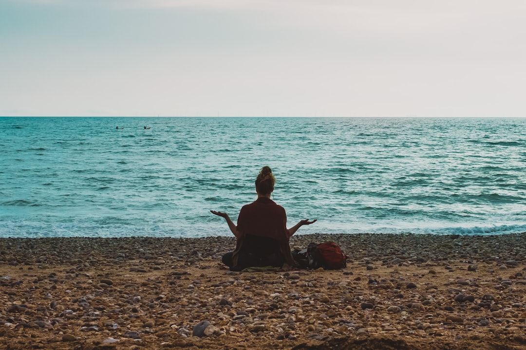 person doing yoga on seashore during daytime