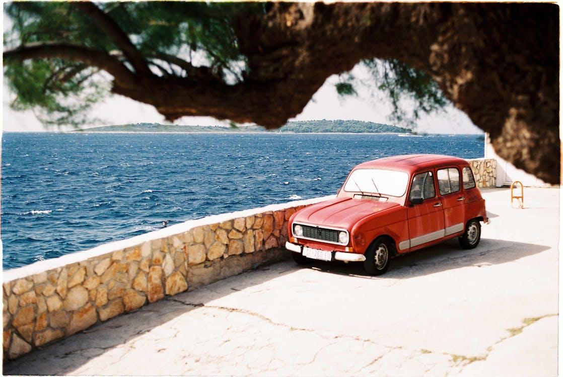 Free Red Car Parked near Body of Water Stock Photo