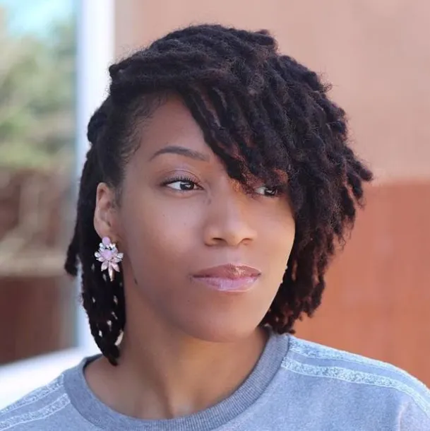 Full picture  of a lady rocking a short dreadlocks 