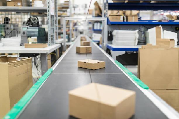 stock photos, royalty-free photos & images of cardboard boxes on conveyor belt at distribution warehouse - belt conveyor systems