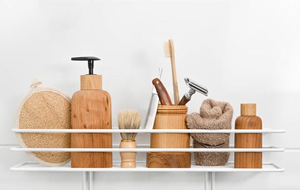 Wooden bottles of grooming care products in bath Close up natural wooden bottles of cosmetic beauty care products, towels, hygiene, grooming and shaving accessories on bath shelf over white background, low angle view shampoo dispenser stock pictures, royalty-free photos & images