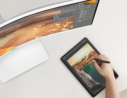 Hand editing photos on a Galaxy tablet wirelessly connected to a Samsung monitor positioned in front