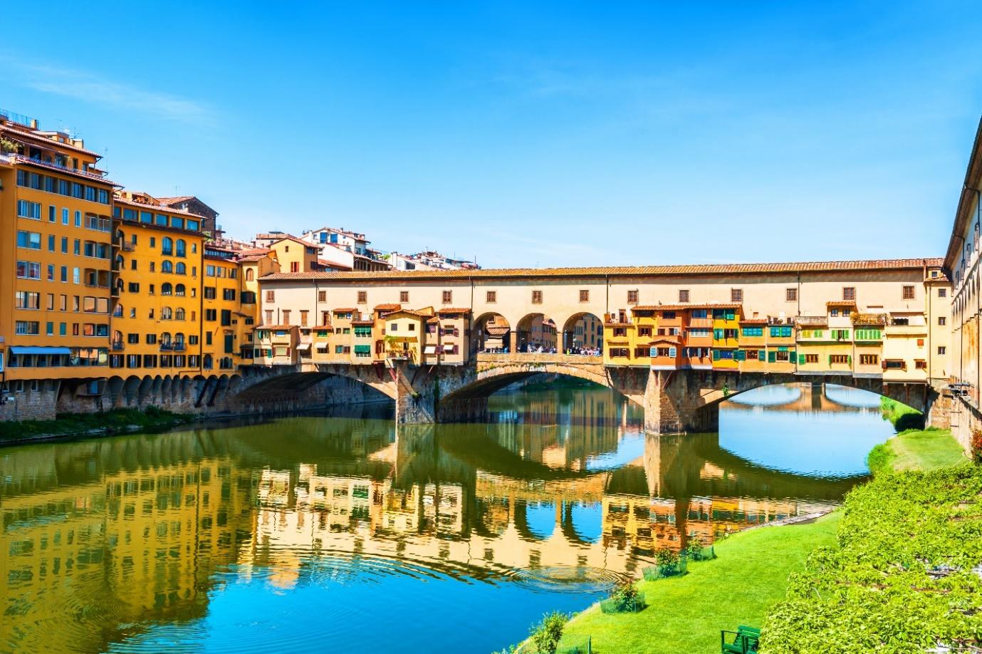 Ponte Vecchio over water with buildings and a body of water

Description automatically generated
