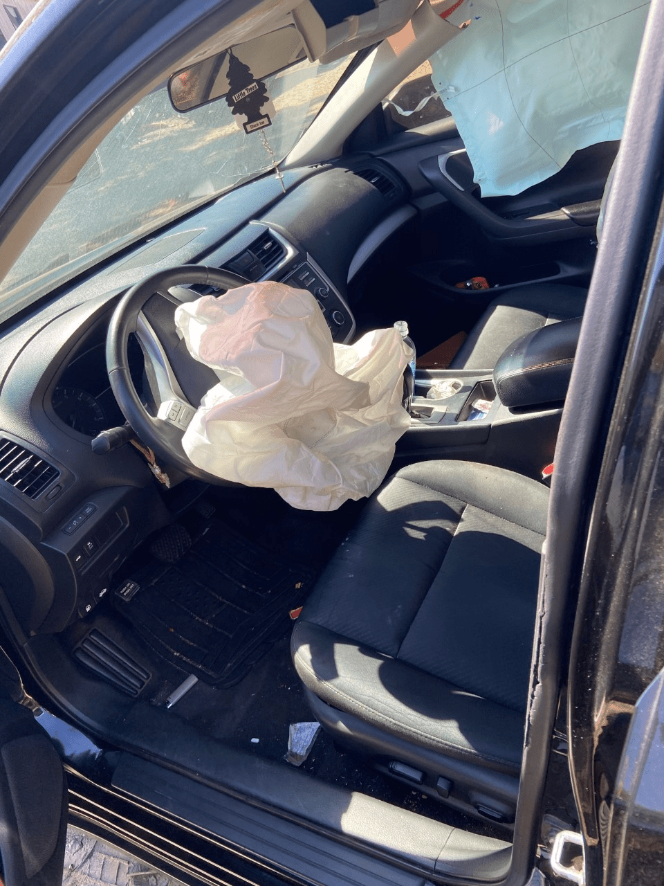 La vista de la puerta del lado del conductor de un automóvil involucrado en un accidente automovilístico en Charlotte.  El accidente automovilístico provocó que se desplegaran las bolsas de aire del lado del conductor y de impacto lateral.
