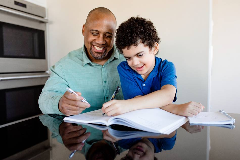 pai ensinando tarefa ao filho sendo exemplificando a união entre escola e familia