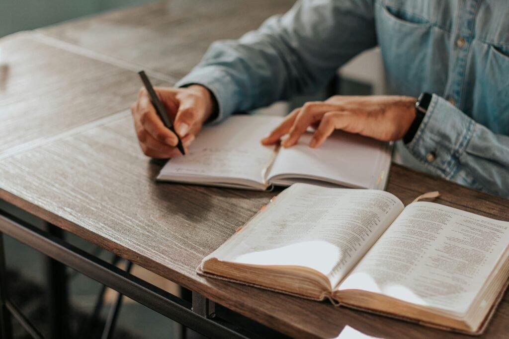 person making notes from book - How to Study for Midterms