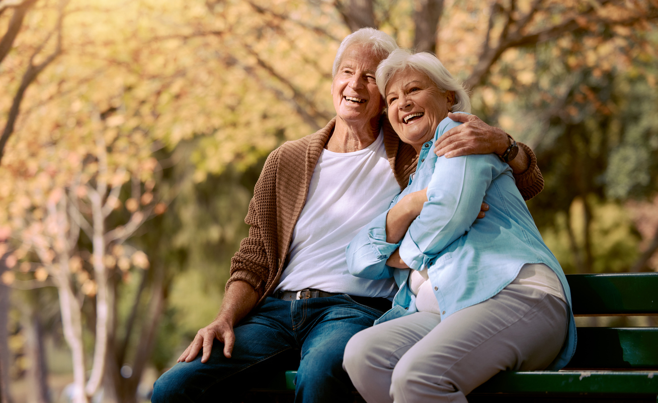 happy senior couple sitting on a bench