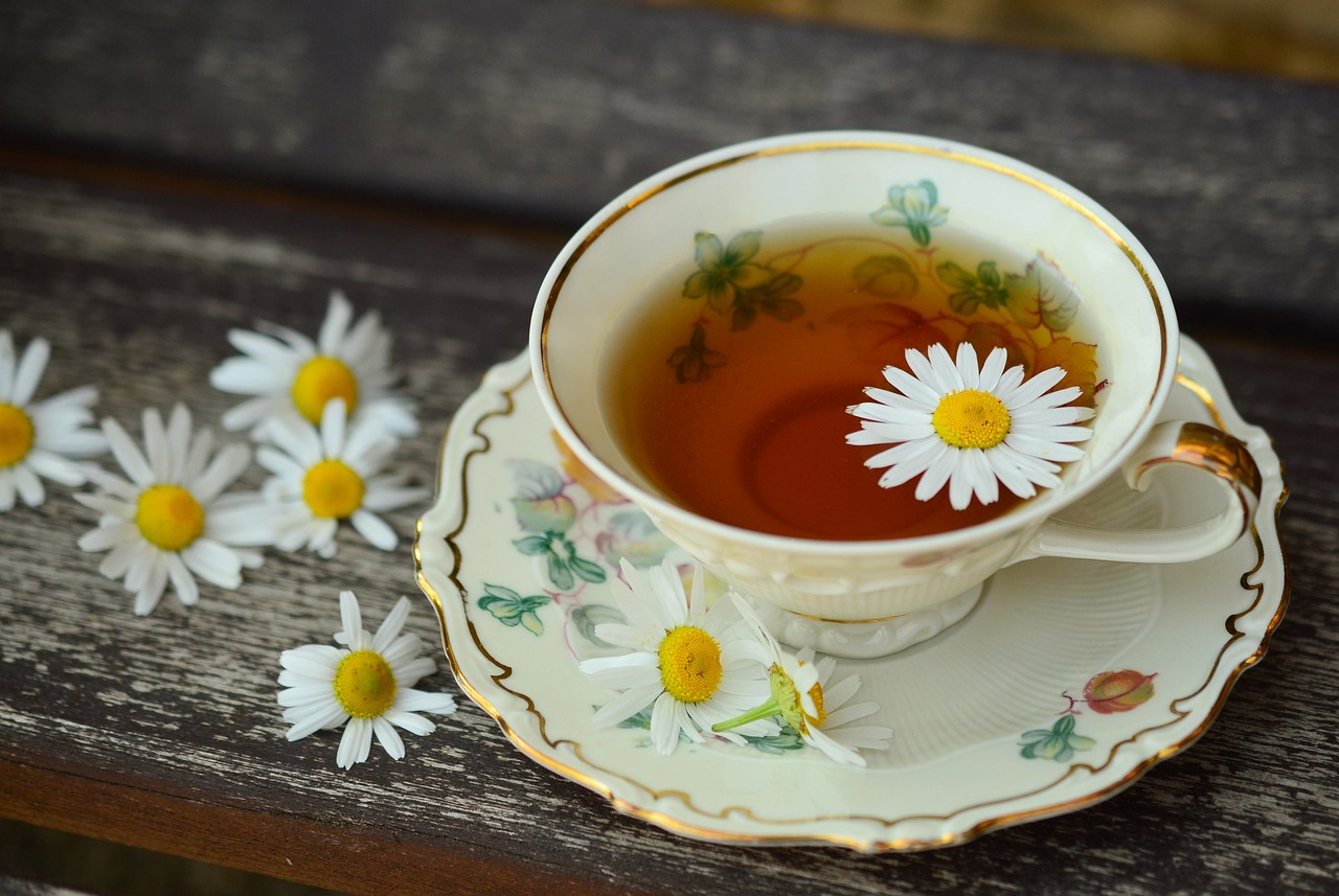 A cup of tea with flowers on a saucer

Description automatically generated