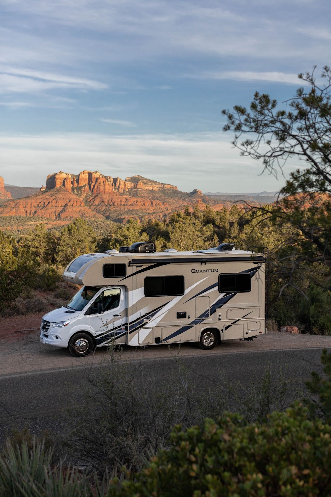 Class C motorhome with red rocks in background