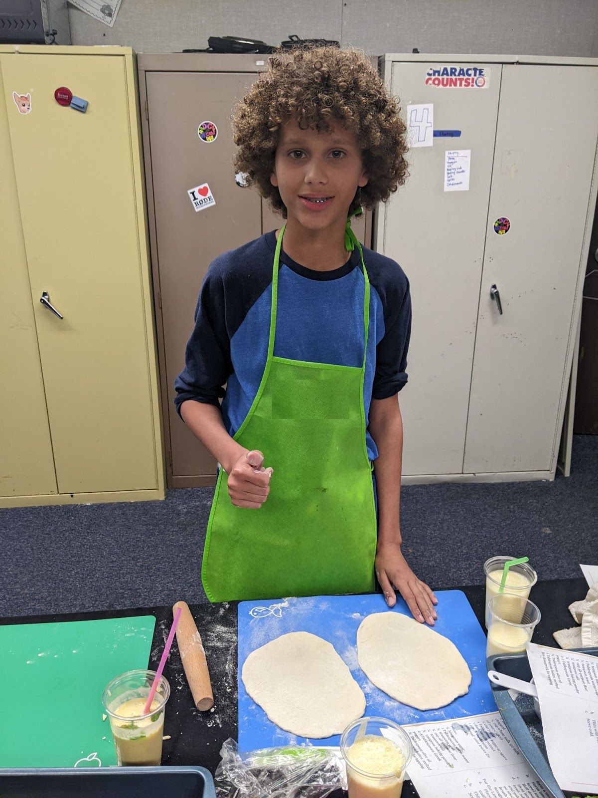 A student smiling and making food. 