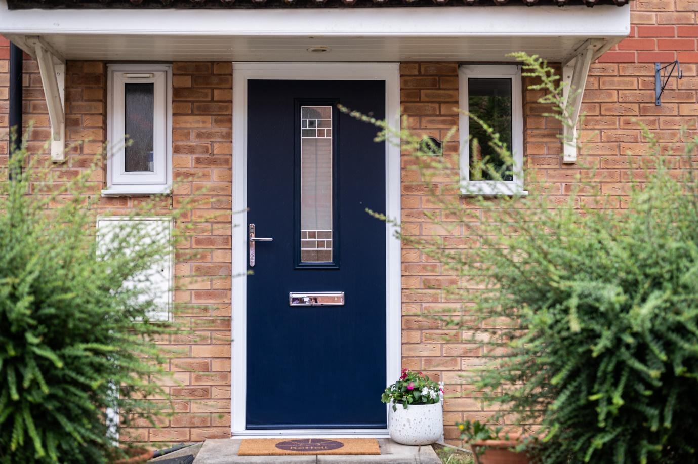 A blue door in front of a brick building

Description automatically generated