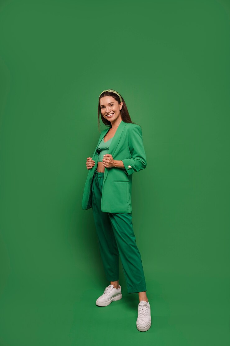 A woman posing in a green outfit.