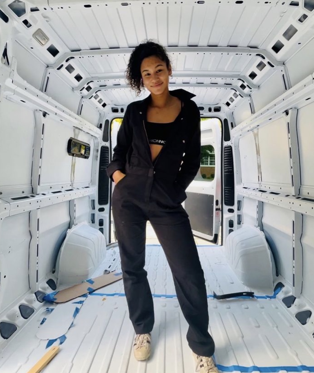 Woman standing in an empty van at the start of her van conversion. 