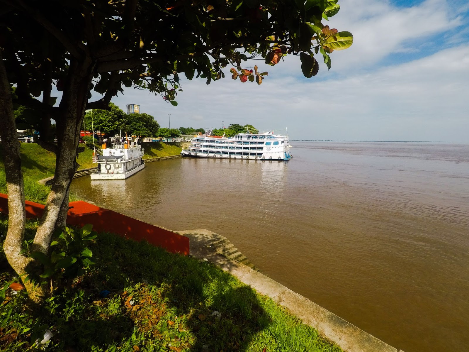 Doi barcos usados para transporte e turismo pelo rio Amazonas, ancorados à margem de Parintins