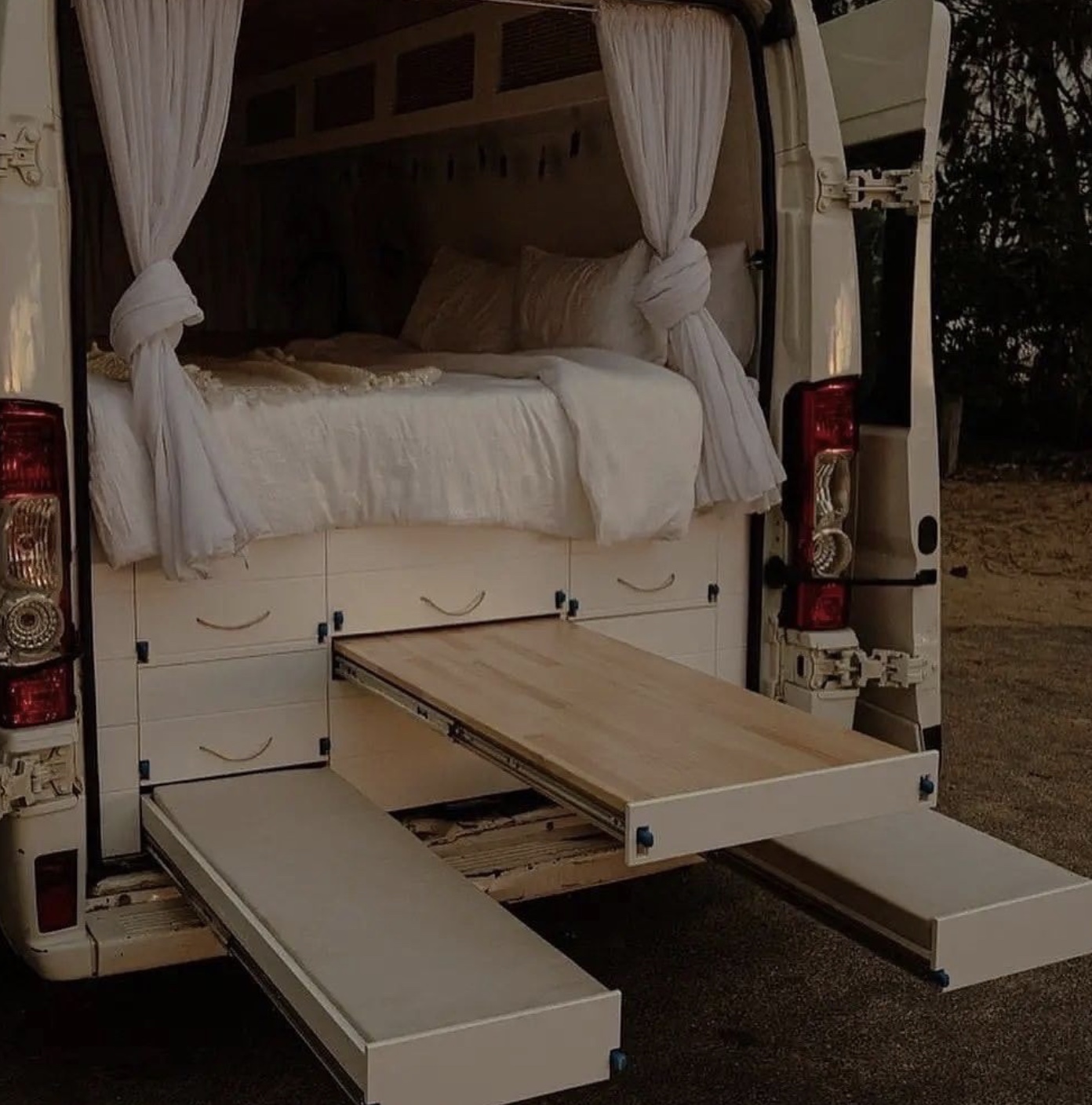 Practical pull out storage nested under the bed in a van. 
