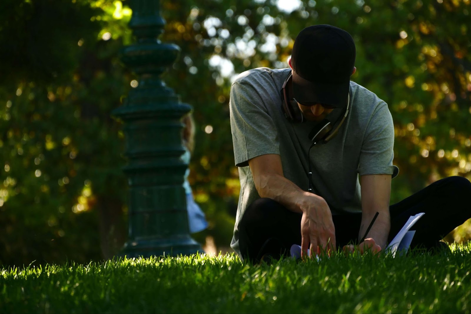 man writing in a journal outside for benefits of self-care