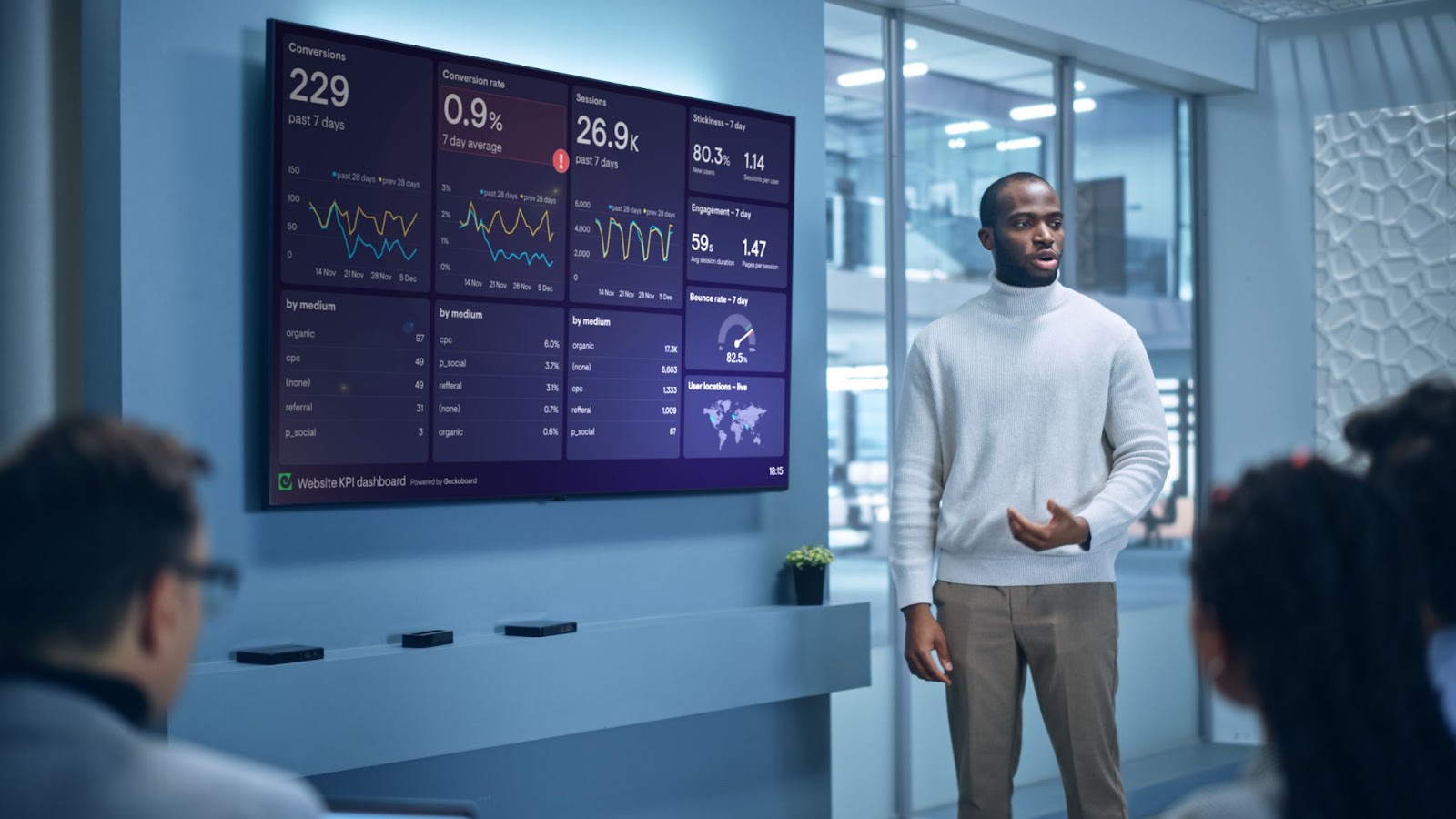 Man standing next to digital marketing dashboard.