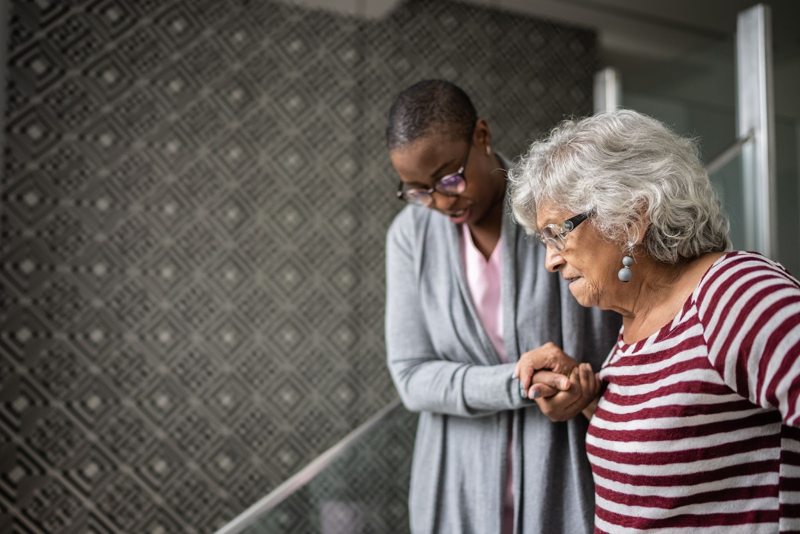 senior lady with caregiver going down stairs