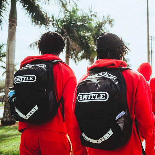 Two football players walking side by side wearing Battle Vault athletic backpacks