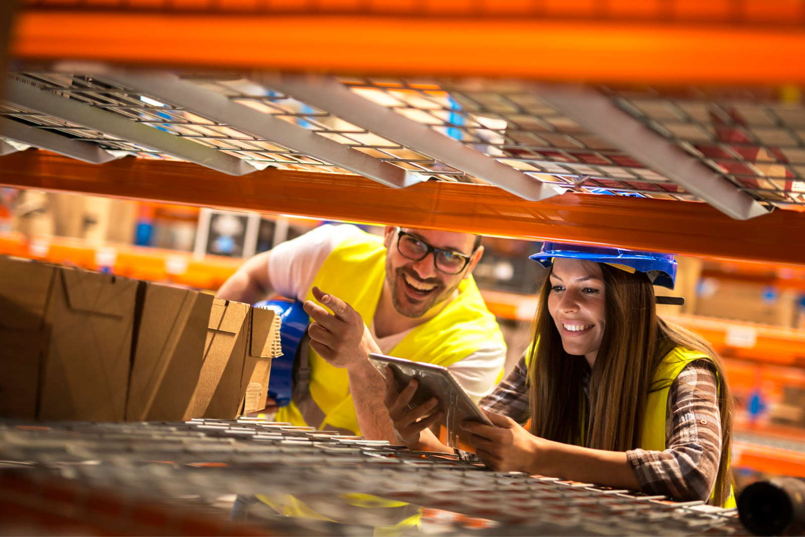 Two workers looking into a warehouse rack.