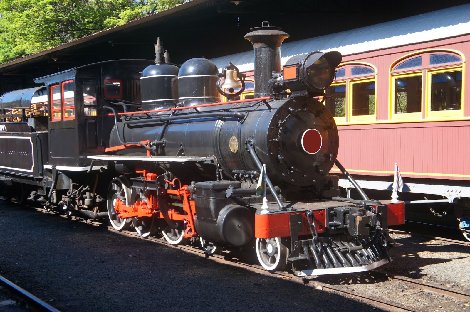 Locomotiva de ferro Maria Fumaça preta com detalhes em vermelho.