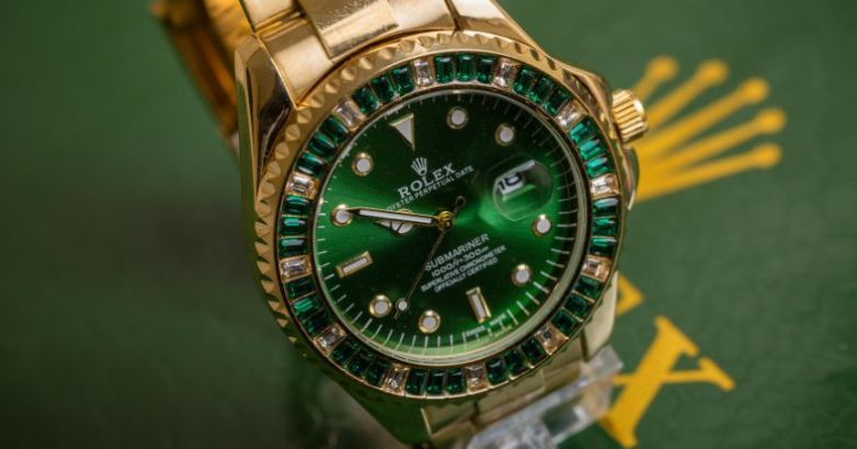 A luxury watch with gold and green color by the Rolex